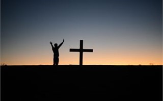 hands lifted by cross