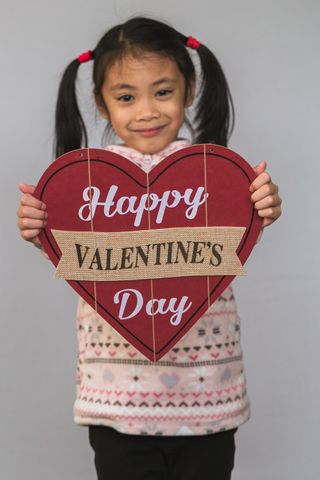 child holding a valentine sign